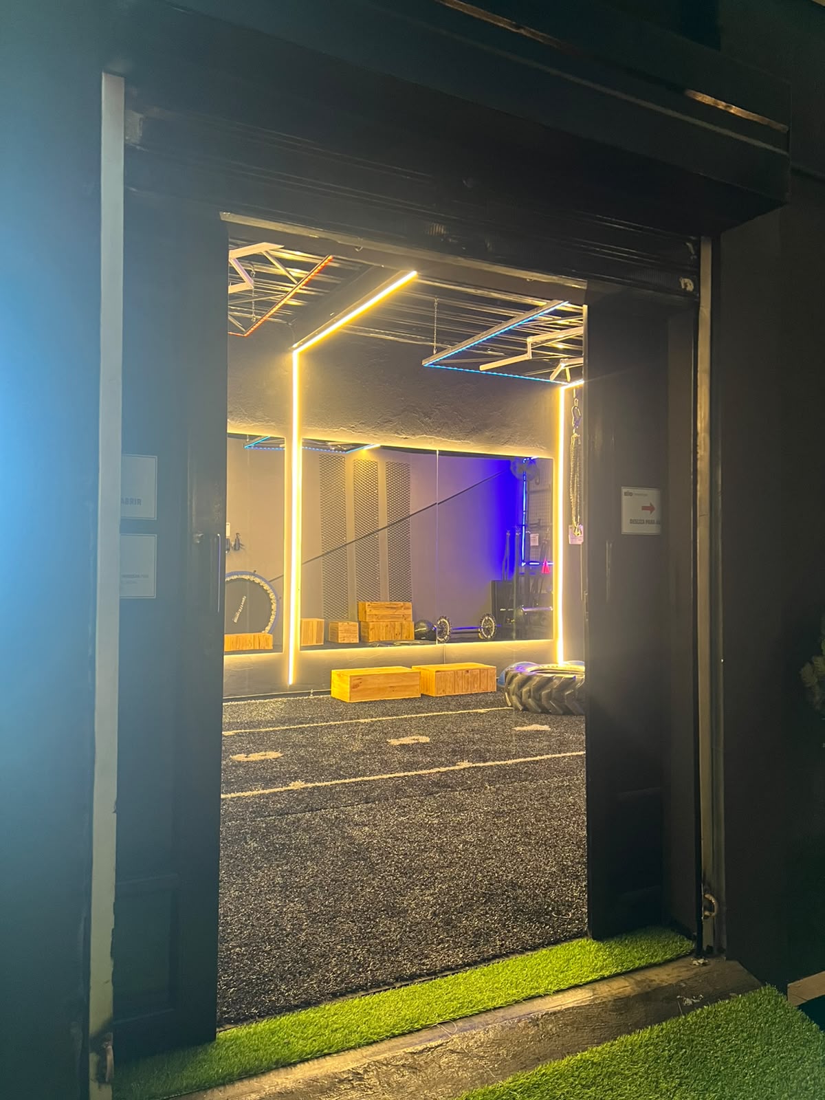 Puerta de entrada del Training Room iluminada, con la pista al fondo